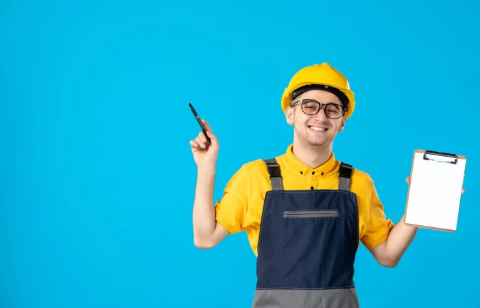 front-view-cheerful-male-builder-uniform-with-file-note-his-hands-blue-wall